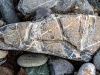 Tiefe Riefen und weiße Maserung in keilförmigem Stein